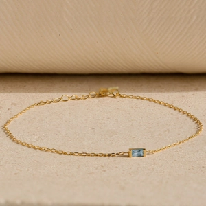 Macro shot of gold s925 silver bracelet with rectangular blue birthstone inlay