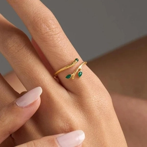 Elegant gold tree branch open ring with green enamel leaves on a female finger