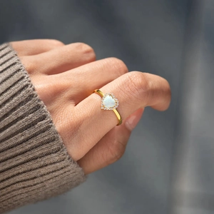 Bague en or s925 avec opale cœur et halo de diamants portée par un modèle