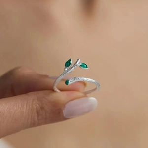 S925 sterling silver tree branch ring with green enamel leaves on a female hand