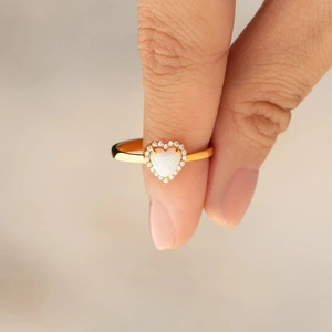 Détail d'une bague cœur en opale et argent S925 plaqué or avec entourage de diamants