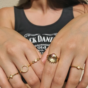 Close-up of a gold stacking ring set featuring a sunburst opal and star patterns