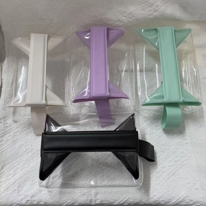 Overhead view of four clear PVC travel makeup bags in white, lilac, mint, and black