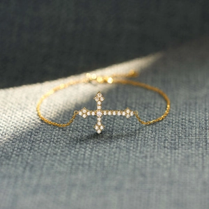 Bracelet croix élégant en argent S925 doré avec zircons brillants sur tissu gris foncé