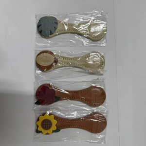 Set of four magnetic leather bookmarks with floral and leaf patterns in individual packaging