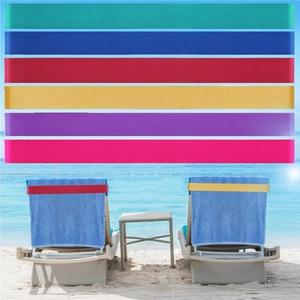 Detailed view of elastic beach towel bands in multiple colors on a poolside lounge chair