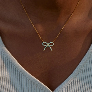 Élégant collier en argent S925 doré avec pendentif nœud en zircon bleu clair sur modèle