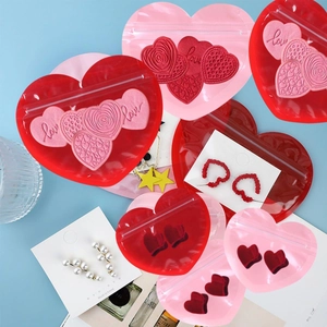 Detail of red and pink heart-shaped PVC jewelry seal bags with love motifs and zippers