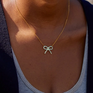 Détail du collier s925 en or avec pendentif nœud en zircon bleu clair sur le mannequin