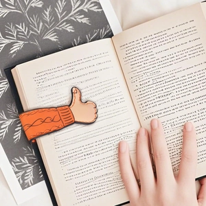Detailed view of orange sweater sleeve thumb magnetic bookmark used on open book pages