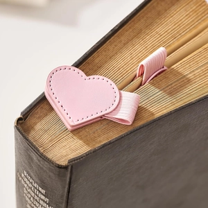 Detail view of pink heart-shaped leather bookmark with pen holder and elastic band