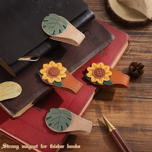 Detail of vintage leather magnetic bookmarks with sunflower design and hand stitching