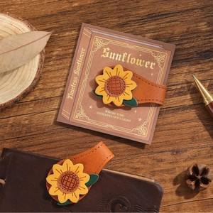 Close-up of magnetic sunflower leather bookmark on a notebook with vintage aesthetic