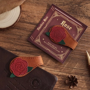 Detailed close-up of handmade rose leather magnetic bookmarks on vintage notebook