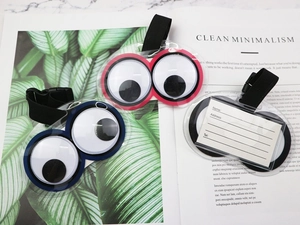 Three colorful PVC luggage tags with googly eyes and reverse side contact information cards