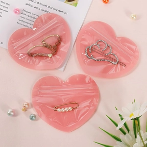 Detail of pink heart-shaped zip-lock bags packaging pearl brooches and jewelry sets