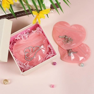 Macro shot of pink heart-shaped PVC jewelry seal bags with rhinestone clips and gift box