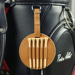 Macro detail of brown leather golf tee holder with five wooden tees on a black bag