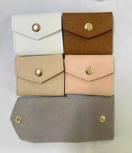 Set of five velvet jewelry pouches in neutral colors with gold metal snap buttons