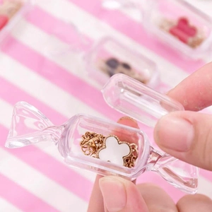 Boîte de rangement transparente en forme de bonbon avec trèfle sur fond à rayures