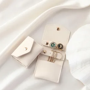 Macro view of compact velvet jewelry pouch with ring holder and snap closure