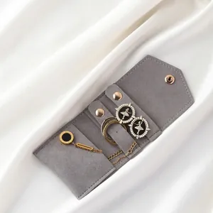 Gray velvet jewelry pouch with rose gold snap closure and internal storage detail