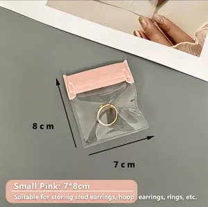 Detailed view of a small pink 7x8cm EVA jewelry storage bag sealing a gold ring