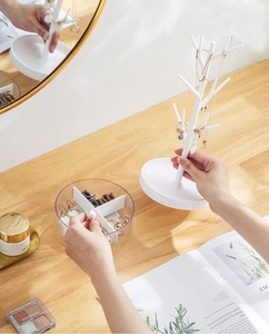 Detailed set of white tree jewelry rack and transparent compartment organizer on a desk