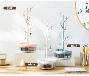 Detailed view of tree-shaped jewelry organizer with rotatable storage drawers in three colors