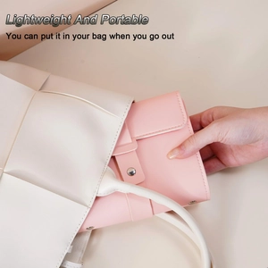 Pink faux leather jewelry organizer being placed into a bag, lightweight and portable