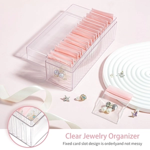 Macro view of clear jewelry storage box featuring fixed card slots and pink sealer bags