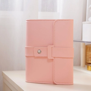 Detail of pink PU leather jewelry organizer with secure silver metal snap button closure