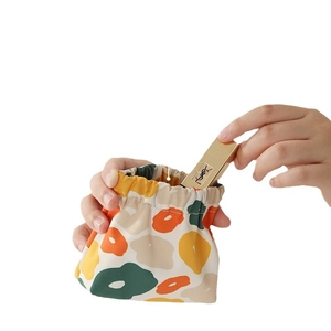 Mini floral waterproof travel pouch for lipstick storage shown in hand on white background