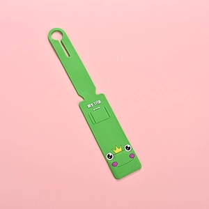 Detail of cute green PVC luggage tag featuring a cartoon frog with crown and my trip text