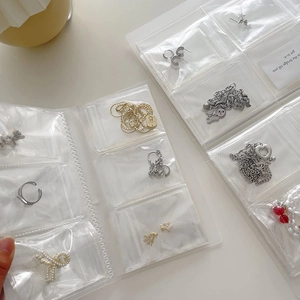 Detailed view of portable transparent PVC jewelry storage book with multi-grid compartments