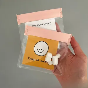 Close-up of a small transparent jewelry storage bag with a pink sealing slide zipper