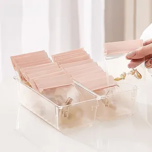Close-up of pink zip-lock jewelry bags with pearl earrings inside a clear plastic storage box