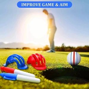 Golf ball marker tool kit with red and blue alignment stencils on a sunny green field