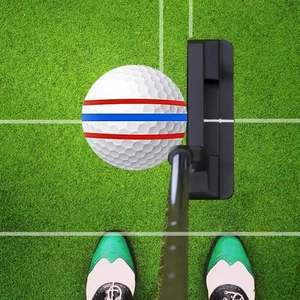 Top view of golf ball with triple alignment lines and professional black putter on green grass