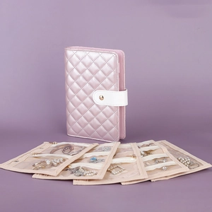 Pink quilted jewelry organizer roll with transparent storage pockets for rings and earrings