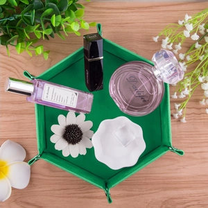 Detailed top view of a green hexagonal foldable leather storage tray with makeup items