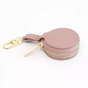 Macro detail of round lychee pattern leather mini jewelry case with gold zipper