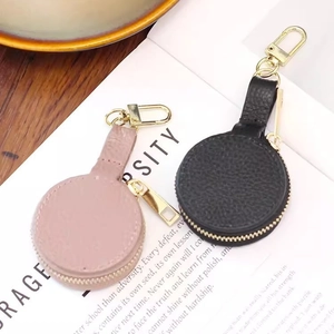 Mini round leather jewelry case in black and pink colors with gold lobster clasp