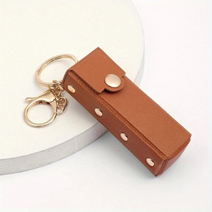 Brown PU leather lipstick holder keychain with gold hardware on a white stand