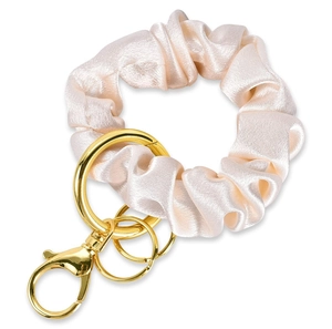 Close-up of champagne satin fabric keychain with golden ring and lobster clasp