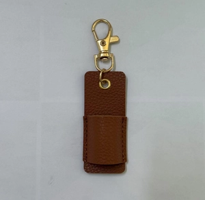 Close-up of brown leather pen holder pouch with gold metal hook and lychee texture