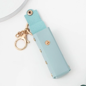 Light blue PU leather mini lipstick pouch keychain with gold metal clasp on white background