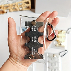 Detail view of a compact Japanese coin organizer in a clear PVC pouch with a black carabiner