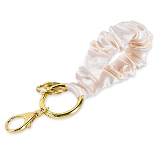 Detail of satin scrunchie keychain with champagne fabric and gold metal lobster clasp