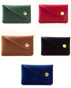 Detail of five handmade leather card holders with gold metal buttons and neat stitching